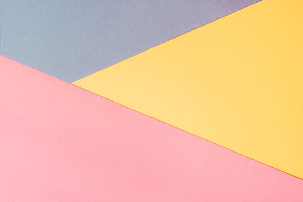 Yellow, pink and blue colored paper. Geometric empty paper background of three tones for copy space.