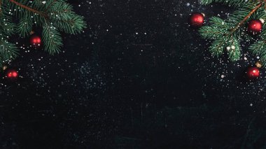 Noel ağacı dalları ve siyah arkaplanda kar ile kırmızı toplar. Yeni yıl konsepti. Üst görünüm, düz görünüm, kopyalama alanı.