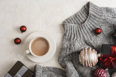Beyaz arka planda gri süvetere bir fincan kahve ve Noel hediyesi. Üst manzara, düz uzanma.