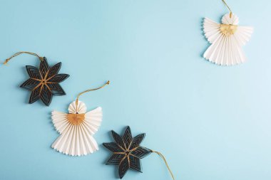 Mavi arka planda kağıt melekler ve köknar ağacı oyuncakları. Noel konsepti. Üst görünüm, düz görünüm, kopyalama alanı.