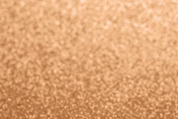 Abstract defocused glitter texture, background. Color of the year 2024 - Peach Fuzz. Copy space.