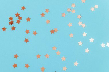 Mavi arka planda altın konfeti. Doğum günü partisi, tatil konsepti. Üst görünüm, alanı kopyala.