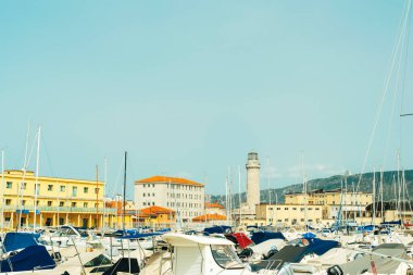 Trieste İtalya - 30 Mart 2024: Mavi gökyüzüne karşı rıhtım ve deniz feneri manzarası.