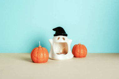 Bej ve mavi arka planda Cadılar Bayramı mumları. Sonbahar odası dekorasyonu, tatil geçmişi..