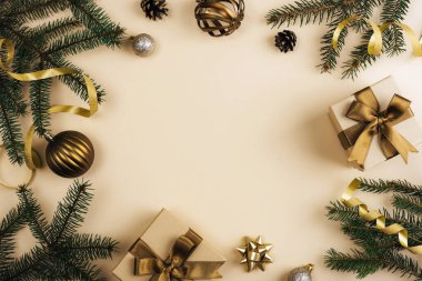 Noel arkaplanı köknar dalları, altın kurdeleler, süsler ve şenlikli düz dizaynlı hediyeler. Üst görünüm, alanı kopyala.