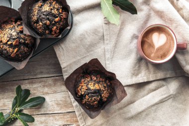 Peçetenin üstünde çikolatalı kek ve kahve fincanı, üst manzara. Kırsal hayat. Yıl Rengi: 2025 Mocha Mousse.