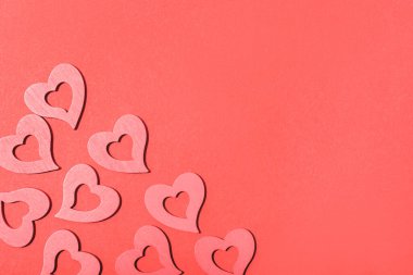 Pembe kalpler, parlak kırmızı bir arkaplanda düzenlenmiş, Sevgililer Günü için fotokopi alanı ile romantik ve şenlikli bir tasarım yaratıyorlar. Üst manzara, düz uzanma.