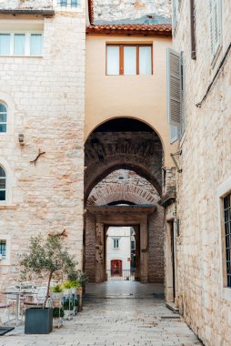 Tarihi bir Avrupa kasabasında eski bir taş kemer yolu. Köy binaları ve açık hava kafesi var. Ayrıl, Hırvatistan.