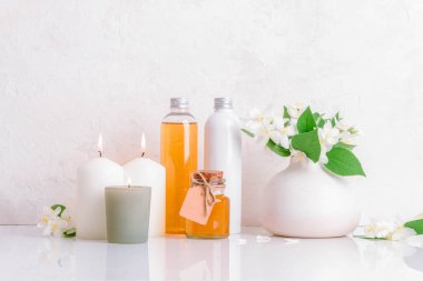 Beyaz arka planda şişe, mum ve yasemin çiçekli kaplıca seti. Sağlık konsepti. Ön görünüm.
