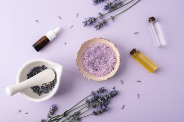 Deniz tuzu, temel yağlar ve pastel arka planda harç içeren lavanta spa bileşimi. Üst manzara, düz uzanma.