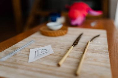 Tahta bir masanın üzerine elle dürtmek için gerekli tüm malzemeler. Çivi ve minimalist dövme tasarımı kağıdı da dahil.