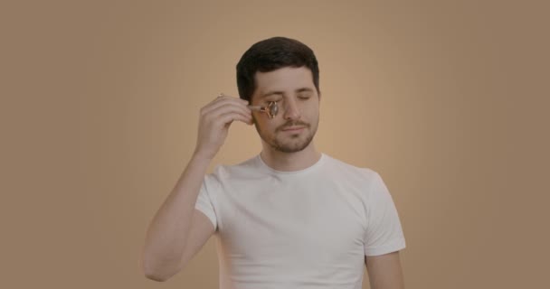 Retrato Jovem Com Rosto Satisfeito Massageando Olhos Com Rolo Jade — Vídeo de Stock
