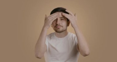 Gülümseyen ve 30 yaşında mayolu yakışıklı bir adam nemlendirici sürüyor ve tüm yüzüne krem sürüyor. Cilt bakımı, profesyonel bakım için reklam kavramı