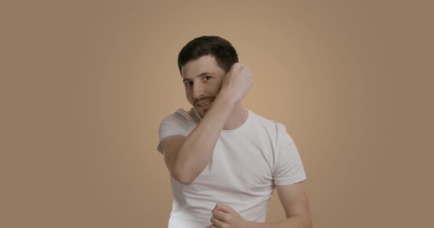 穿着白色T恤 头戴梳子梳头的年轻男子 自信而迷人 看上去像浴室的镜子 早上一个英俊的满脸胡须的家伙在做头发 男人的美发观念 — 图库视频影像