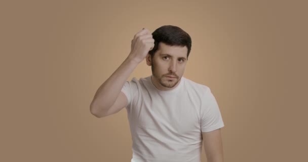 真剣な髭の男がカメラを見て髪の毛をヘアブラシで持ってきた ハンサムな男は仕事の日の準備をしている 健康で美しい髪型の男 朝のヘアカットルーチン — ストック動画