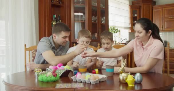 Ευτυχισμένη Οικογένεια Ζωγραφίζει Πασχαλινά Αυγά Στην Κουζίνα — Αρχείο Βίντεο