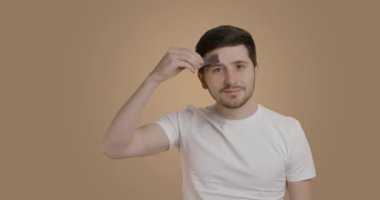 Nice young man doing his grooming routine. Man who takes off his black mask from his face and throws it down. Man satisfied with the effect after the facial mask. Concept of care products