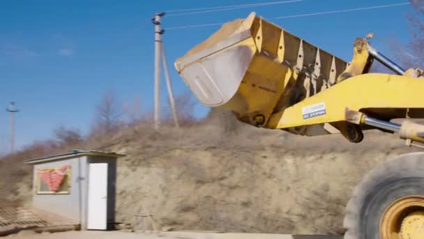 在建筑工地上 一个黄色的工业起重机从前面卸下沙子和一辆拖车 然后筛出水泥 浇注房屋地基的建筑公司的工作过程 — 图库视频影像