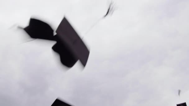 天空中的图像 带着研究生帽 翻腾着 掉进了空隙 学生们在毕业典礼上抛出几个毕业典礼帽 学士和硕士学位的庆祝活动 — 图库视频影像