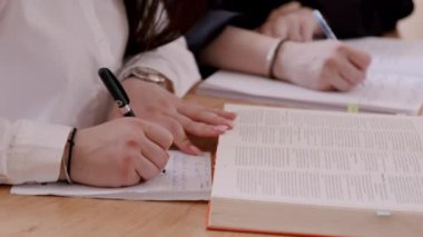 Günlüğe not alan birkaç kişi, yakın çekim görüntüsü. Girişim için fikirler ve iş planları yazan iş kadınları, bir trainig 'de deftere yaratıcı düşünceler yazıyorlar. Yapılacak işler konsepti veya fikir listesi.