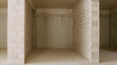 Duvarların hücresel beton tuğlalardan yapıldığı bir inşaat alanı. Gaz bloğundaki yeni binaların boş duvarları. Yeni bir daireye, banyoya beyaz tuğla bir duvar döşenmiş.