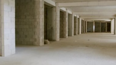 Modern bir beyaz tuğla alışveriş merkezi inşaatı altındaki koridor. Boş ofis alanları yapım aşamasında. Yeni binada beyaz duvarları olan büyük boş bir daire. Hareket halindeki video