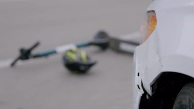 Sürekli yanan hasarlı bir arabanın yakın plan görüntüsü. Kavşakta bir araba ve bir elektrikli scooter arasında trafik kazası. Araba sigorta şirketleri için müşterileri için konsept.