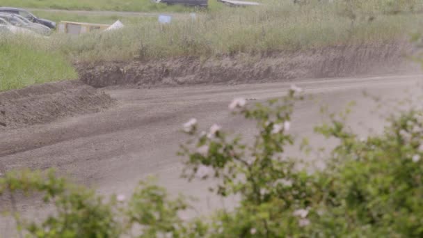 图像来自一场汽车比赛的灰尘 一个驾驶着一辆黑色赛车的司机慢慢地开始朝比赛预定的路线驶去 一条满是灰尘和颠簸的道路 — 图库视频影像