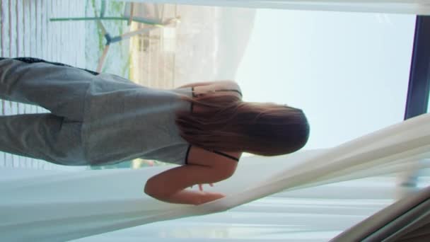 Particuliere Huisvrouw Trekt Gordijn Kijkt Door Panoramische Ramen Slaapkamer Verticale — Stockvideo