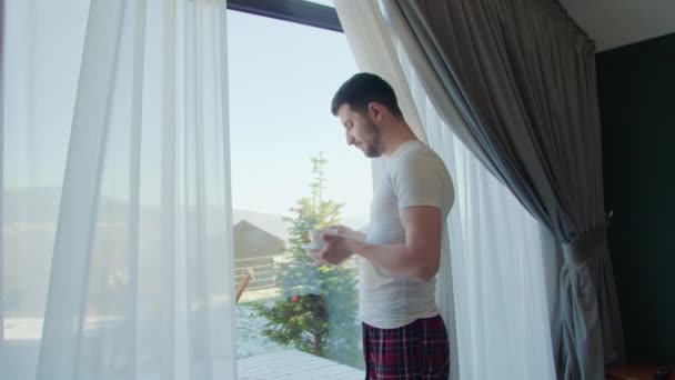 Seseorang Berdiri Dengan Penuh Perhatian Melihat Melalui Jendela Panorama Meminum — Stok Video
