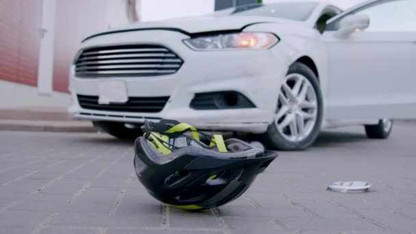 涉及一名骑自行车者的交通事故 前面是头盔 后面是一辆被骑自行车的人撞倒的汽车 描述了撞车的后果 — 图库视频影像