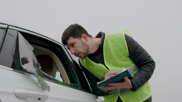 壊れた窓で車を記録する保険検査官 正確に捕獲された破壊行為の鮮やかな描写 — ストック動画