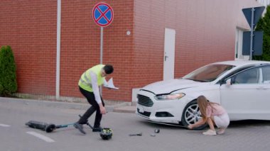 Trafik kazası: Hasarlı beyaz araba, müfettiş ve kadın ölçü alıyor.