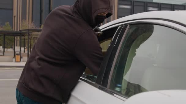 Zloděj Černé Mikině Ukradne Notebook Rozbitým Oknem Auta Zaparkovaného Nákupním — Stock video