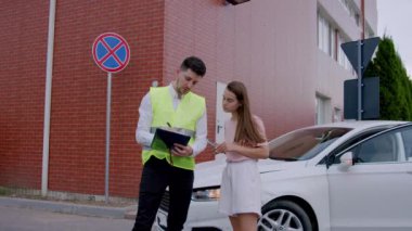 Erkek müfettiş kadın sürücülere ceza kesmiş. İhlalleri titizlikle kaydediyor. Gelecekteki ihlallere karşı sert uyarılar yapıyor. Tüm yollara daha güvenli cezalar veriyor.