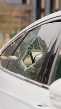 Kapüşonlu suç, arabanın camını kırdı. Parlak hırsız dikey videosu. Arabanın camını kıran kişi camını kıran suç işleme maksadıyla araba camını kıran kişi çalınan eşyaların huzurunu bozan kişi.