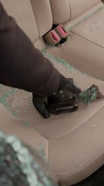 Parçalanmış cam araba hırsızlığı sonucu araç dikey videosu içinde savunmasız bırakılan değerli eşyalara hızla el koyuldu. Çalınan eşyalar, sahibini kayıp hissiyle boğuşurken, hikayenin ihlalini tekrarlar.