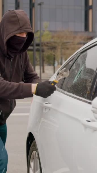 Капюшоном Злочинець Розбиває Вікно Автомобіля Краде Речі Вертикальне Відео Кожним — стокове відео