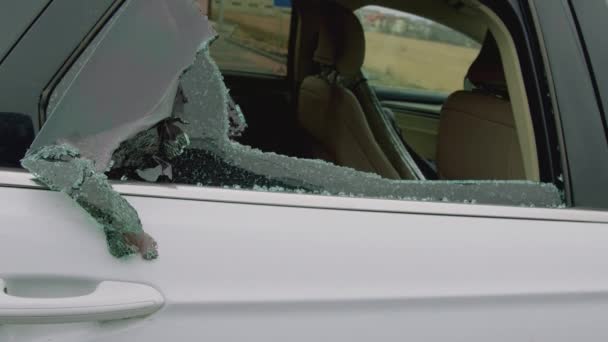 特写镜头拍摄的汽车碎玻璃犯罪现场 破碎的玻璃碎片散落在座位上 破坏了人们的鲁莽行为 清楚地揭示了破碎的汽车玻璃造成的破坏程度 — 图库视频影像