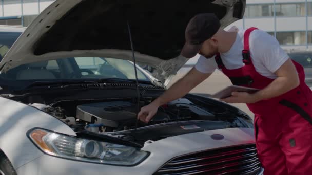 修理破碎的汽车机械师 展示了汽车维修的熟练程度 汽车罩打开 司机观察到汽车修理的复杂性 — 图库视频影像
