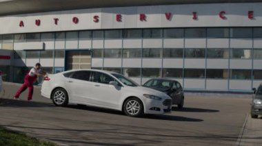 Odaklanmış çabayla adam otomotiv tamircisine olan bağlılığının sembolü olarak aracı itiyor. İnsan mekanik zorluklar karşısında aracın dayanıklılığını zorluyor