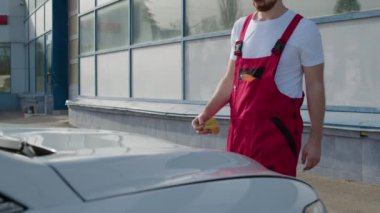 Motor tamiri için kaput açılırken, tamirci otomobil servisindeki değerli işin özünü gösterdi. En uygun araç performansını sağlamak için detaylara ve adanmışlığa titizlikle dikkat edilmeli.