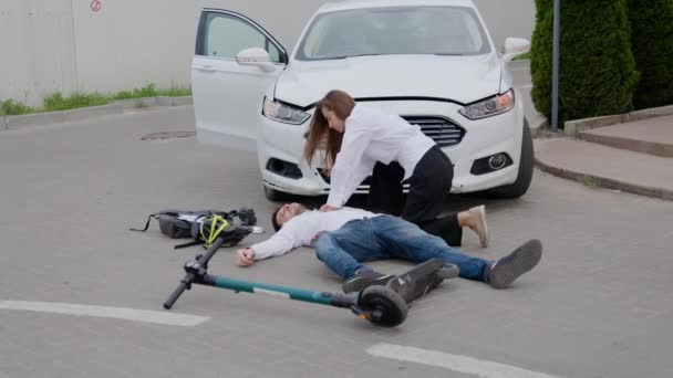 スクーターの事故ドライバーの後 助けるために車のラッシュの地上女性の運転手に負傷しています 運転中の警戒の重要な道路事故の余波の後のシーン — ストック動画