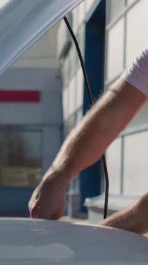 Otomotiv Servis Tamirhanesi Araba Tamircisi dikey video. Kapüşonlu araç açık tamirci aracını destekledi. Önemli bir iş arabası tamiri.