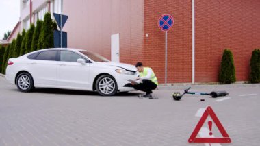 Artçı araba ve elektrikli scooter çarpışması müfettişi kazanın etkilerini ölçmek için titizlikle teşhis muayenesi yapıyor. Kazaların analizinde uzmanların kritik rolü