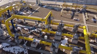 Endüstriyel tesis ağı canlı sarı borular çeşitli sıvı üretim süreçlerini kanalize eder. Bu borular su kimyasallarını iletir. Üretimi destekleyen karmaşık bir altyapı sergiler.