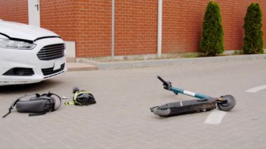 Araba ve motorsiklet hasarlı scooter 'ın karıştığı çarpışma, araç kazasından sonra zeminde yatar. Otomobil kazasının ardından elektronik scooter düştü. Çarpışma oldu.