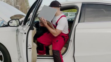 Otomotiv teknisyeni dizüstü bilgisayarı otomobil servisinin içinde tanısal testler yapıyor. Araçların arızalandığını belirliyor. Araba tamirhanesinde çalışan yetenekli bir tamirci modern teknoloji dizüstü bilgisayarını kullanarak araba üretimini analiz ediyor.