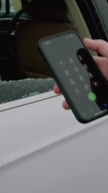 112 acil yardım videosunu çeviren parçalanmış araba camı gördükten sonra yakın plan el ele tutuşan telefon. 112 kırık otomobil camını çeviren bir el telefonu yakalıyor ve duruma tepki veriyor.