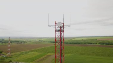 Elektrik kablolarıyla radyo iletişim anteni gökyüzü arkaplanından dağınık bulutlarla geçiyor. Kule, elektromanyetik yakalama için bir bina görevi görüyor. Kablosuz anten bağlantısı.